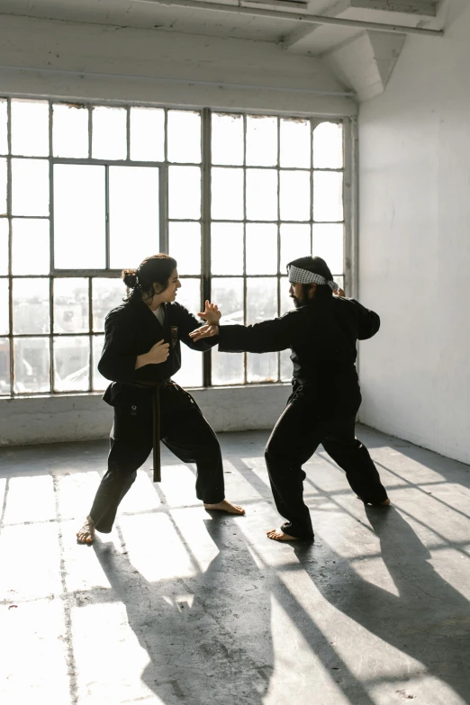 a couple of people that are in a room, inspired by Ma Quan, unsplash, combat stance, in black uniform, manuka, dueling