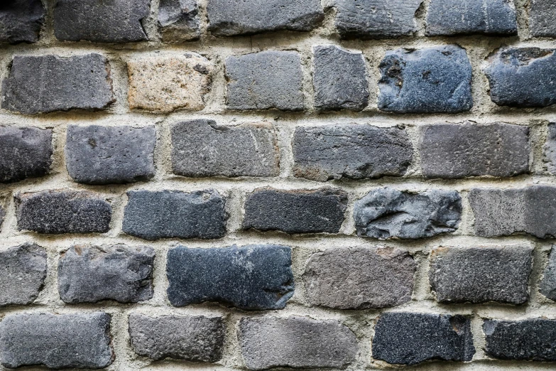 a black fire hydrant sitting on top of a brick wall, an album cover, by Jan Kupecký, unsplash, minimalism, old stone wall, background image, blue gray, perfectly tileable