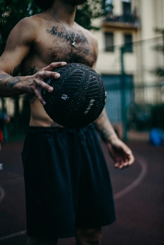 a man standing on a basketball court holding a ball, a tattoo, by Adam Rex, pexels contest winner, black underwear, playing soccer, made of rubber, texture