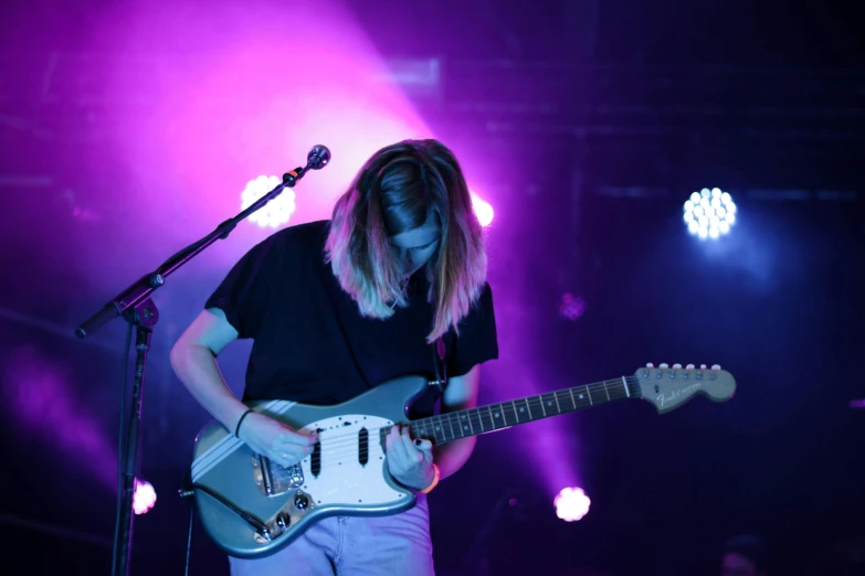 a person that is playing a guitar on a stage, by Alice Mason, electrified hair, washed out, high quality photo, syd