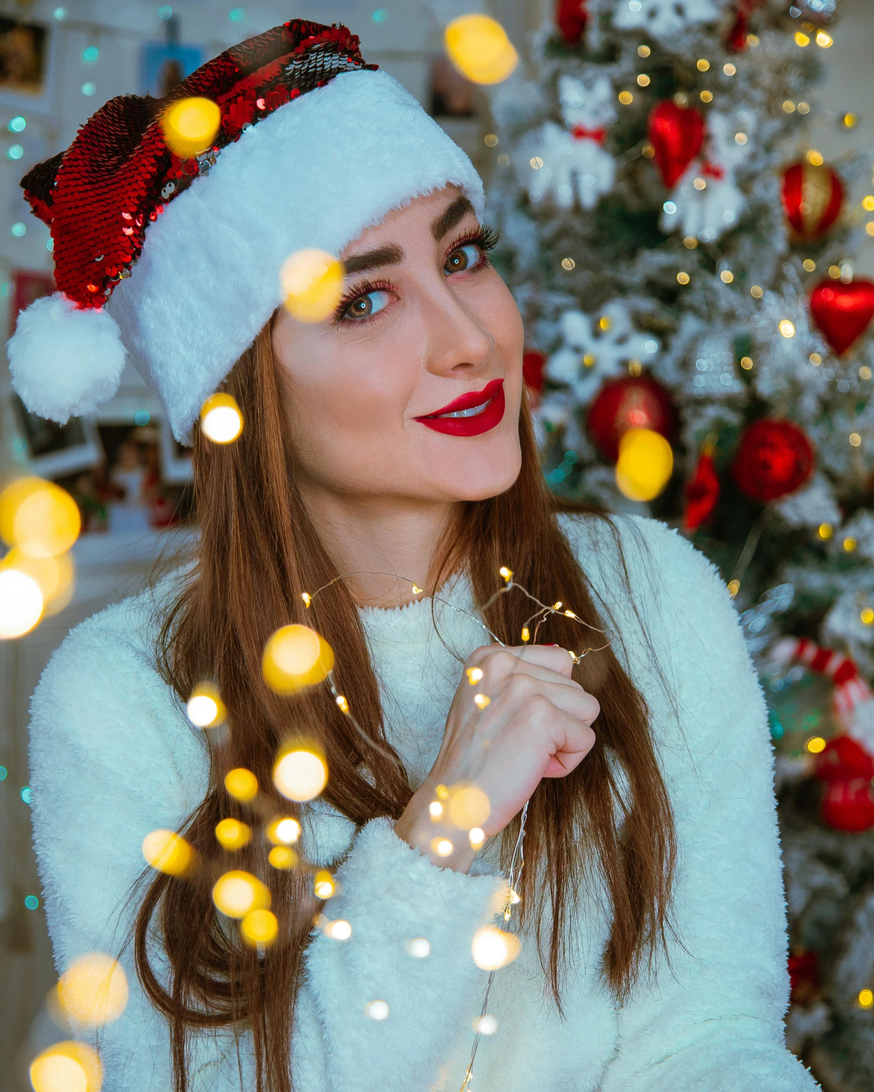a woman wearing a santa hat standing in front of a christmas tree, by Julia Pishtar, trending on pexels, hurufiyya, better known as amouranth, dressed in a beautiful white, glitter gif, portrait mode photo