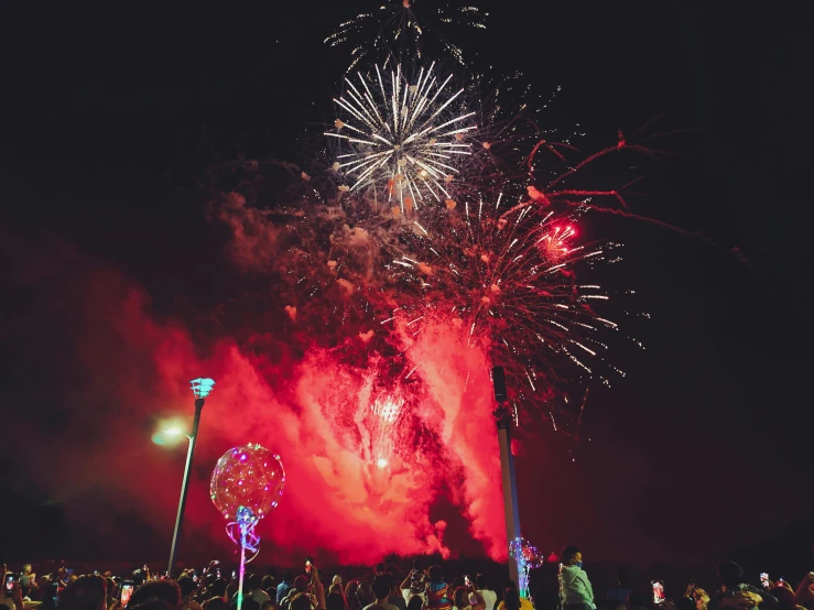 a crowd of people watching a firework display, by Lee Loughridge, pexels, teal silver red, instagram post, profile image, thumbnail