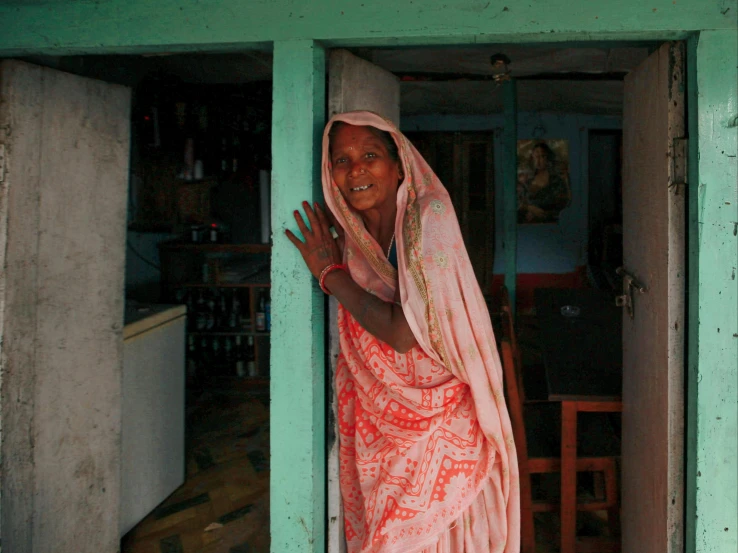 a woman standing in the doorway of a house, ranjit ghosh, portrait image