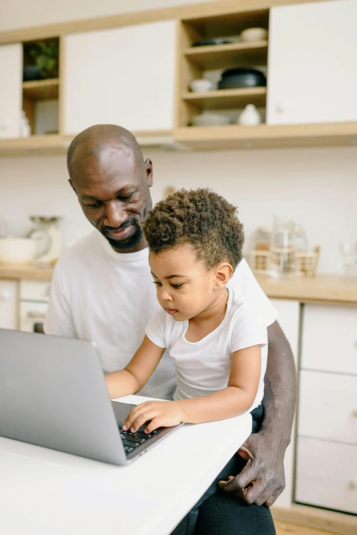 a man and child using a laptop in a kitchen, pexels contest winner, afro tech, thumbnail, inspect in inventory image, day time