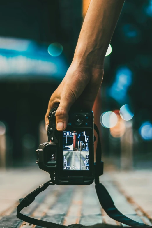 a person taking a picture with a camera, by Adam Marczyński, taken in the night, holding it out to the camera, full frame image, instagram post