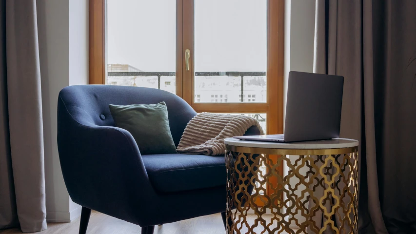 a chair in front of a window with a laptop on it, a portrait, trending on unsplash, gold and indigo, winter blue drapery, central hub, on a coffee table