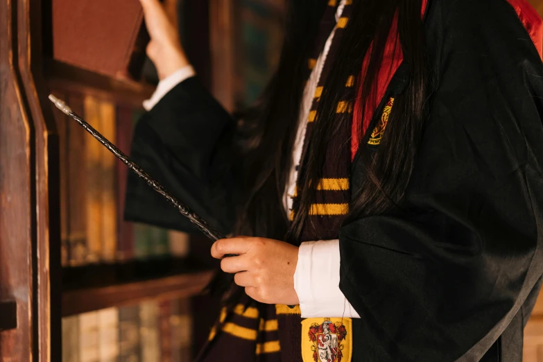 a woman in a harry potter costume holding a wand, trending on pexels, academic art, seifuku, embroidered robes, instagram story, hogwarts gryffindor common room
