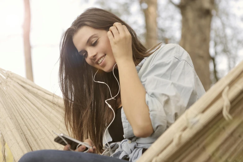 a woman sitting in a hammock listening to music, trending on pexels, teenage girl, wearing casual clothing, subtle detailing, a handsome