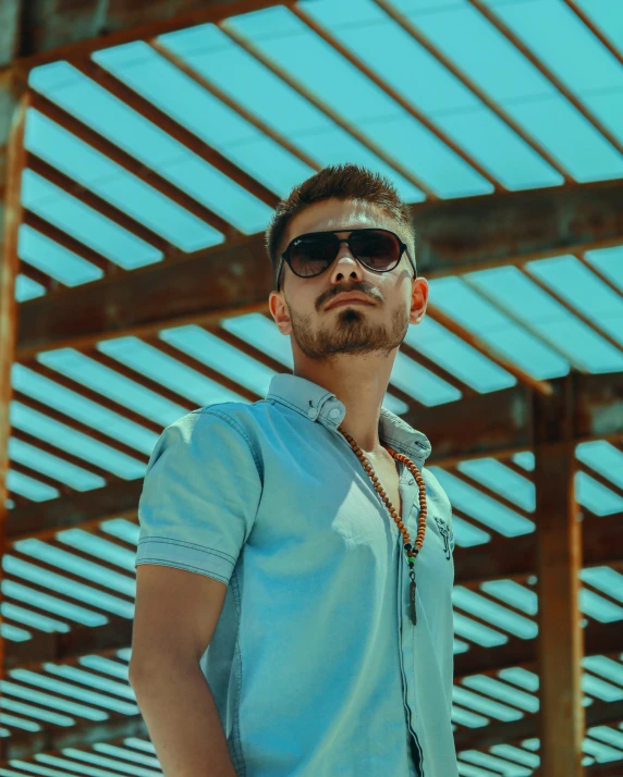 a man wearing sunglasses and a blue shirt, inspired by Michael Ray Charles, pexels contest winner, aestheticism, non binary model, asher duran, official screenshot, color picture