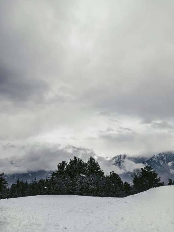 a man riding a snowboard down the side of a snow covered slope, by Muggur, unsplash, hurufiyya, cloudy overcast sky, panorama view, today\'s featured photograph 4k, mount olympus