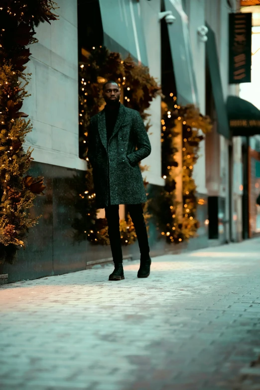 a man standing on a sidewalk in front of a building, by Adam Saks, trending on unsplash, wearing festive clothing, wearing hunter coat, standing in a dimly lit room, grey pants and black dress shoes