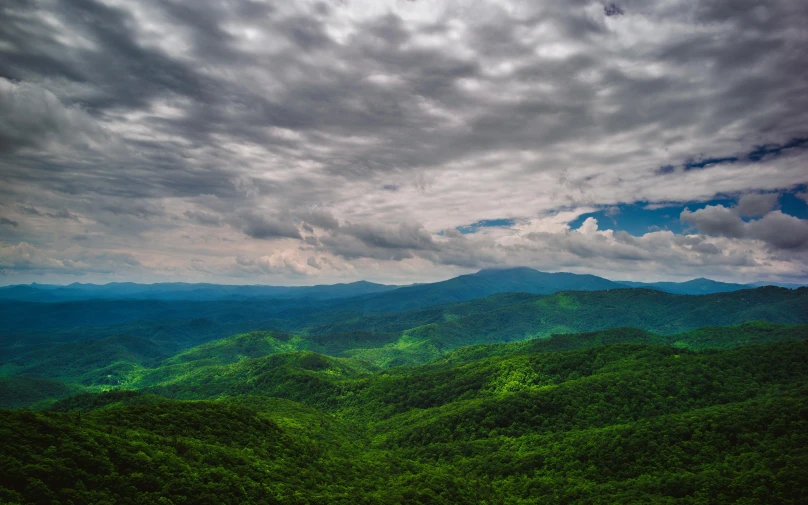 a view of the mountains from the top of a mountain, unsplash contest winner, hudson river school, lush green forest, appalachian mountains, stormy overcast, 8k resolution”