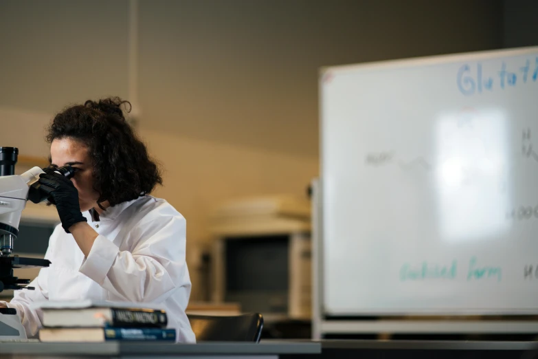 a woman in a lab coat looking through a microscope, unsplash, ashcan school, whiteboards, lachlan bailey, profile image, rebecca sugar