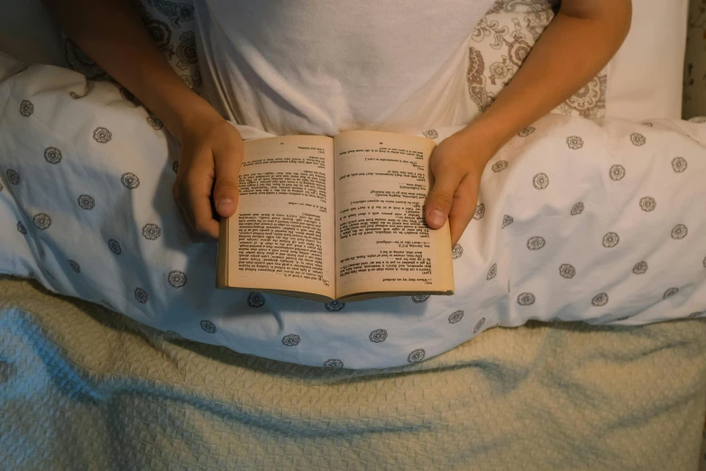 a person laying in bed reading a book, by Carey Morris, pexels, renaissance, nightgown, old testament, full body image, reading engineering book