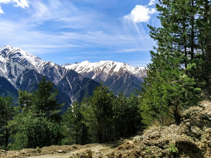 a red fire hydrant sitting on the side of a dirt road, by Muggur, pexels contest winner, hurufiyya, lush forest in valley below, snowy peaks, panorama view, avatar image