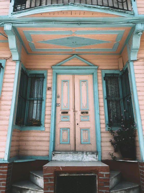 a pink house with a blue door and balcony, a colorized photo, trending on unsplash, art nouveau, brown and cyan color scheme, new orleans, peaceful wooden mansion, background image