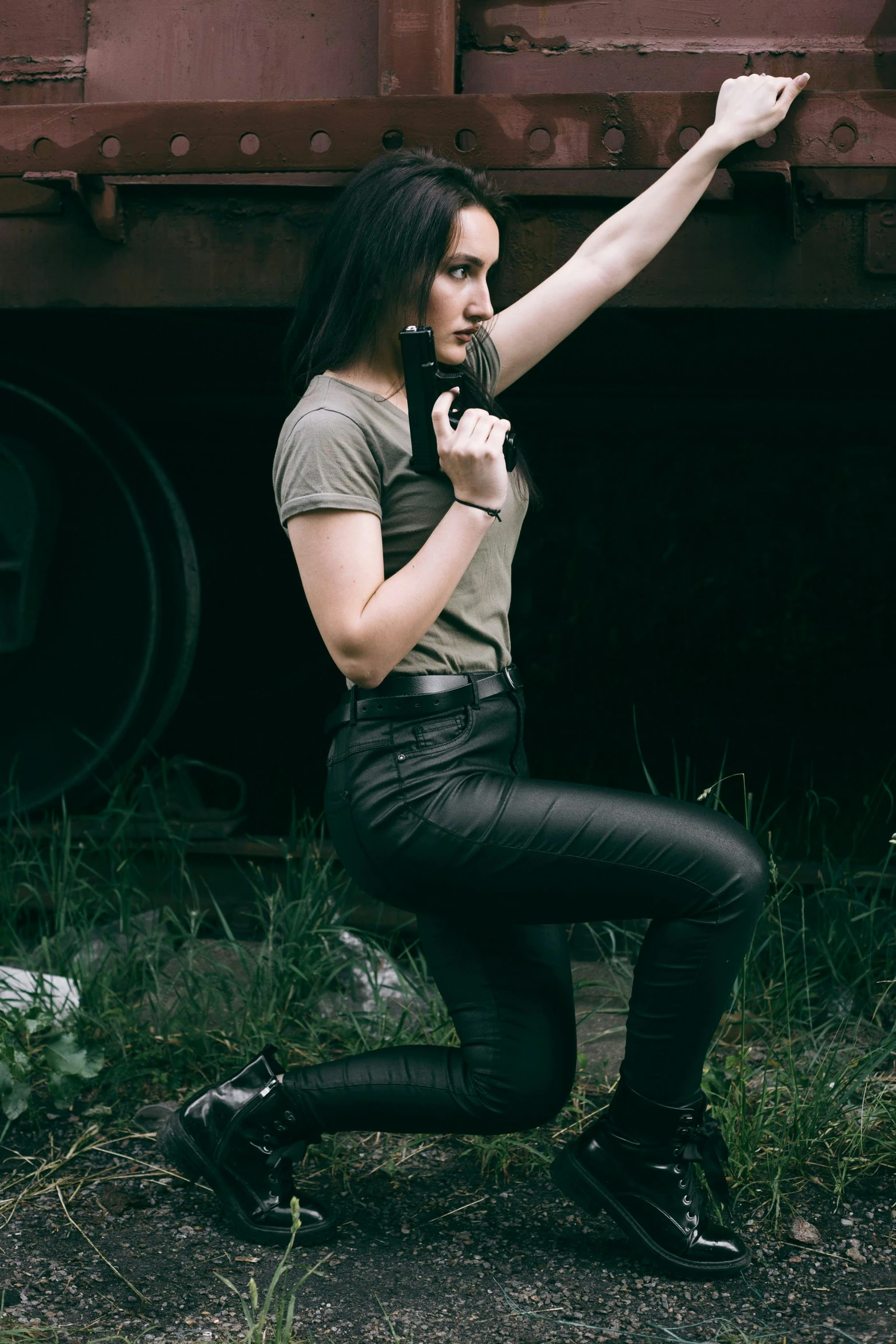 a woman posing for a picture in front of a train, an album cover, pexels contest winner, leather pants, combat pose, amouranth, wearing pants and a t-shirt