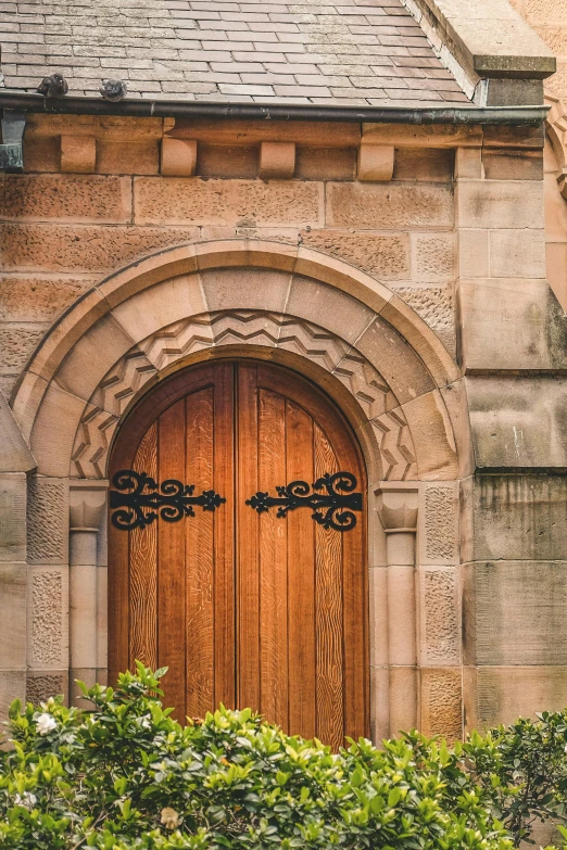 a large wooden door on the side of a building, inspired by Sydney Prior Hall, pexels contest winner, arts and crafts movement, gothic arch frame, brown, churches, glasgow