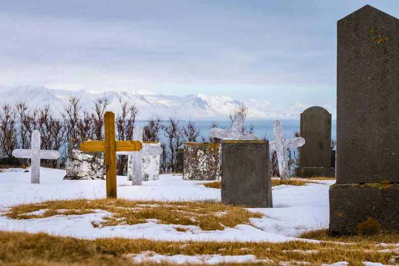 a group of tombstones sitting on top of a snow covered ground, by Jesper Knudsen, pexels contest winner, views to the ocean, avatar image, cementary, cross