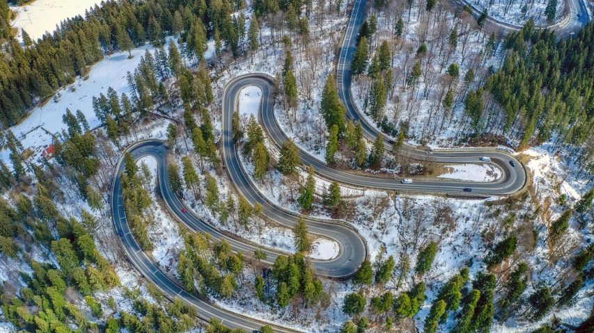 a winding road in the middle of a forest, by Werner Gutzeit, pexels contest winner, visual art, winter season, serpentine curve!!!, automotive, tubing