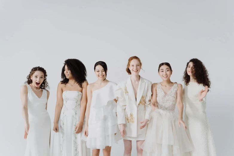 a group of women standing next to each other, trending on pexels, renaissance, wearing a white tuxedo, ivory pale skin, white sky, ignant