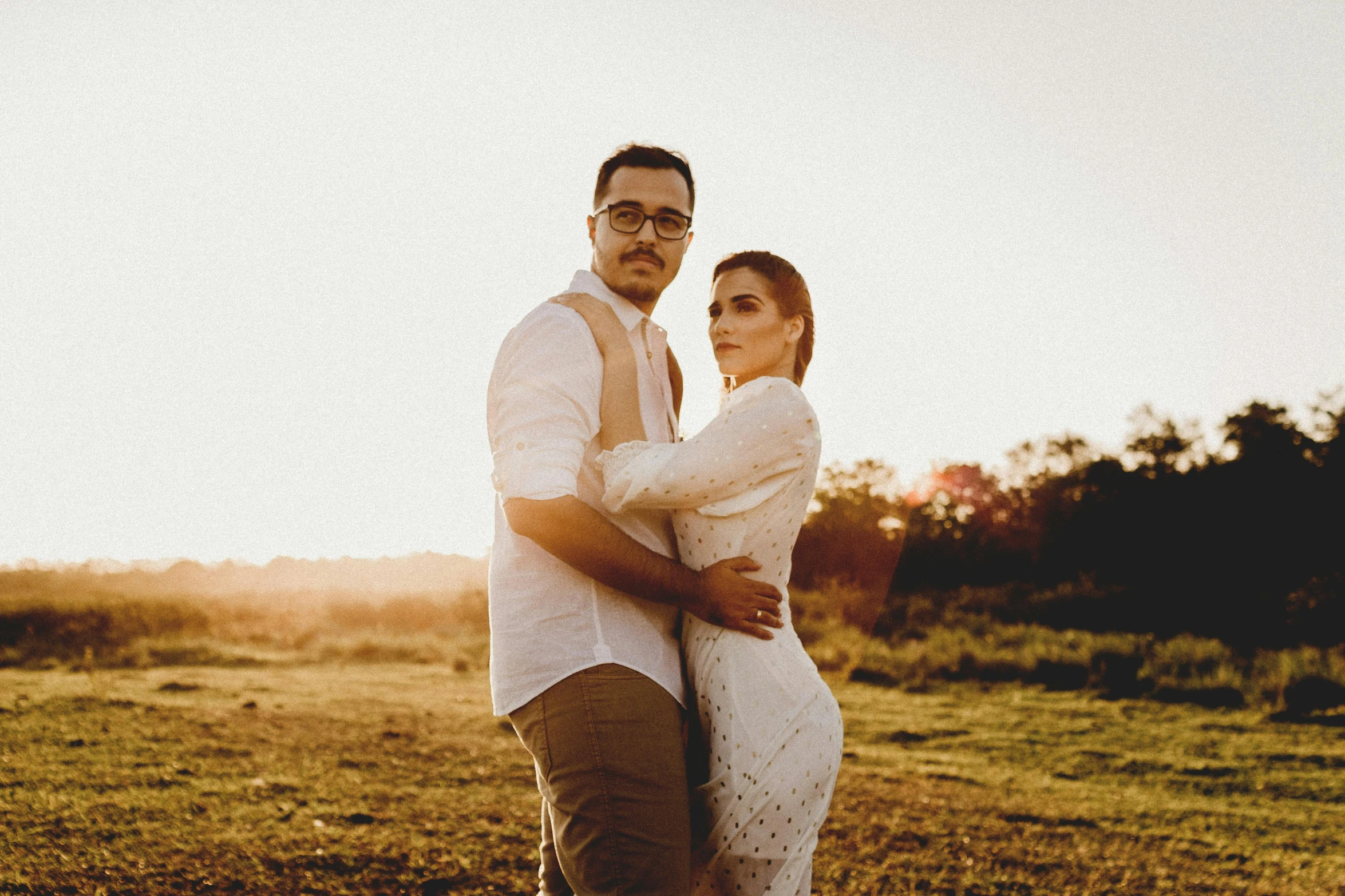 a man and a woman standing in a field, an album cover, pexels contest winner, hispanic, warm glow, portrait mode photo, shaded