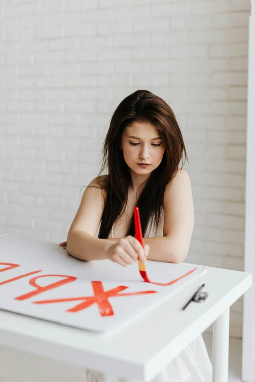 a woman sitting at a table writing on a piece of paper, an airbrush painting, trending on pexels, analytical art, red writing, sexuell, x, low quality photo