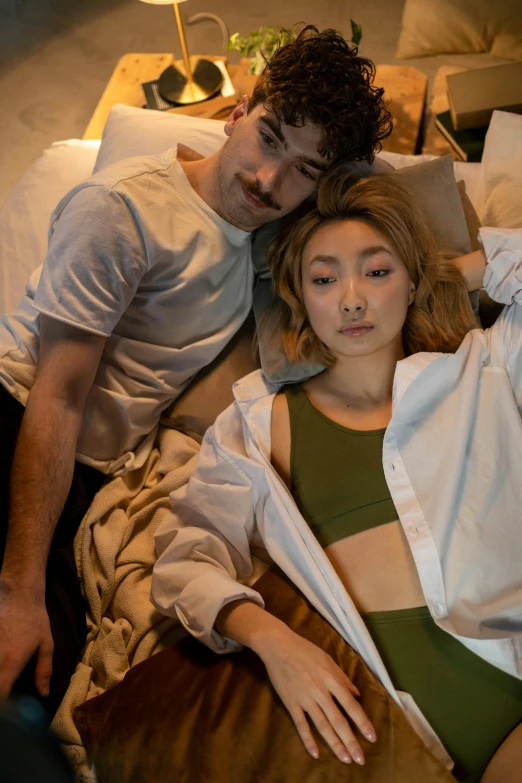 a man and a woman laying on a bed, a portrait, inspired by Nan Goldin, trending on pexels, south korean male, imogen poots d&d paladin, lulu chen, ( ( theatrical ) )