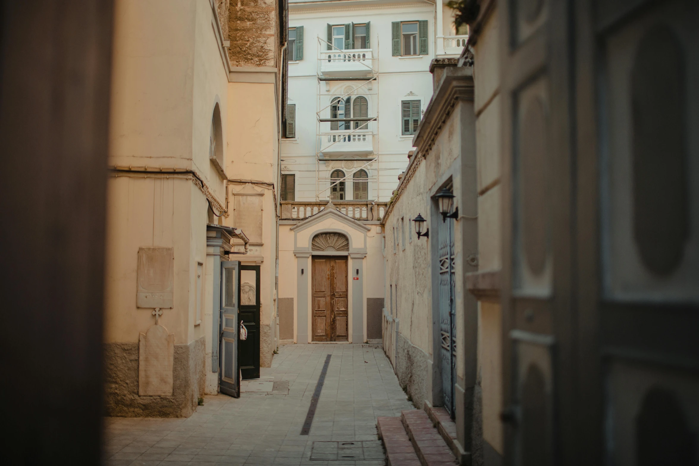 a narrow street with a building in the background, pexels contest winner, neoclassicism, secret entrance, profile image