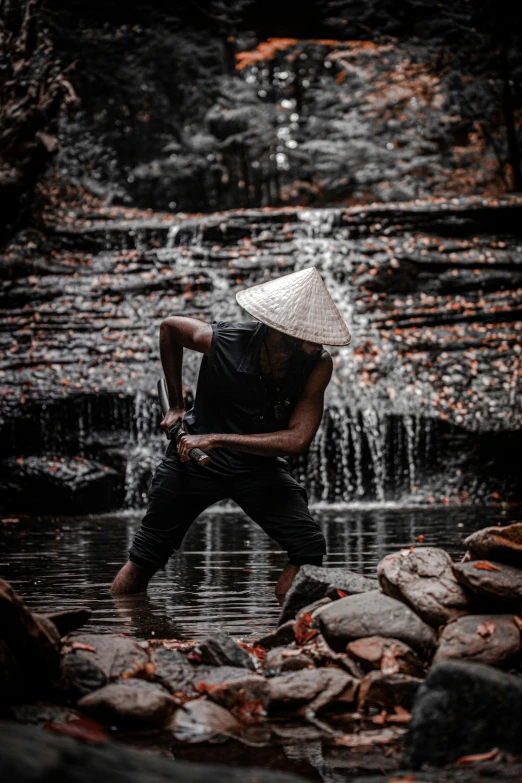 a man standing in front of a waterfall, inspired by Ma Quan, sumatraism, black pointed hat, crouching, highly reflective, performance