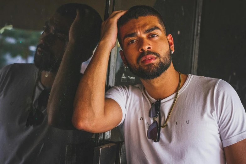 a man standing in front of a mirror with his hand on his head, pexels contest winner, hurufiyya, drake's face, man in white t - shirt, charli bowater and artgeem, leaning against the window