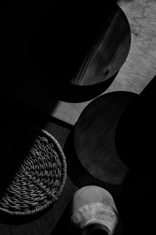 a couple of bowls sitting on top of a wooden table, a black and white photo, lyrical abstraction, three moons, weave, abstract album cover, detailed shadows