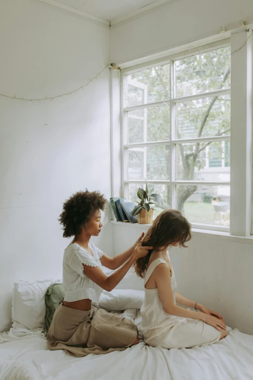 a woman combing another woman's hair on a bed, by Jessie Algie, pexels contest winner, in a white boho style studio, big windows, 4k), with afro