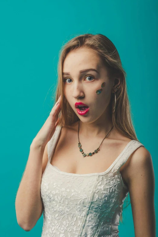 a woman with a surprised look on her face, an album cover, inspired by Elsa Bleda, trending on pexels, small necklace, portrait sophie mudd, 15081959 21121991 01012000 4k, teal studio backdrop