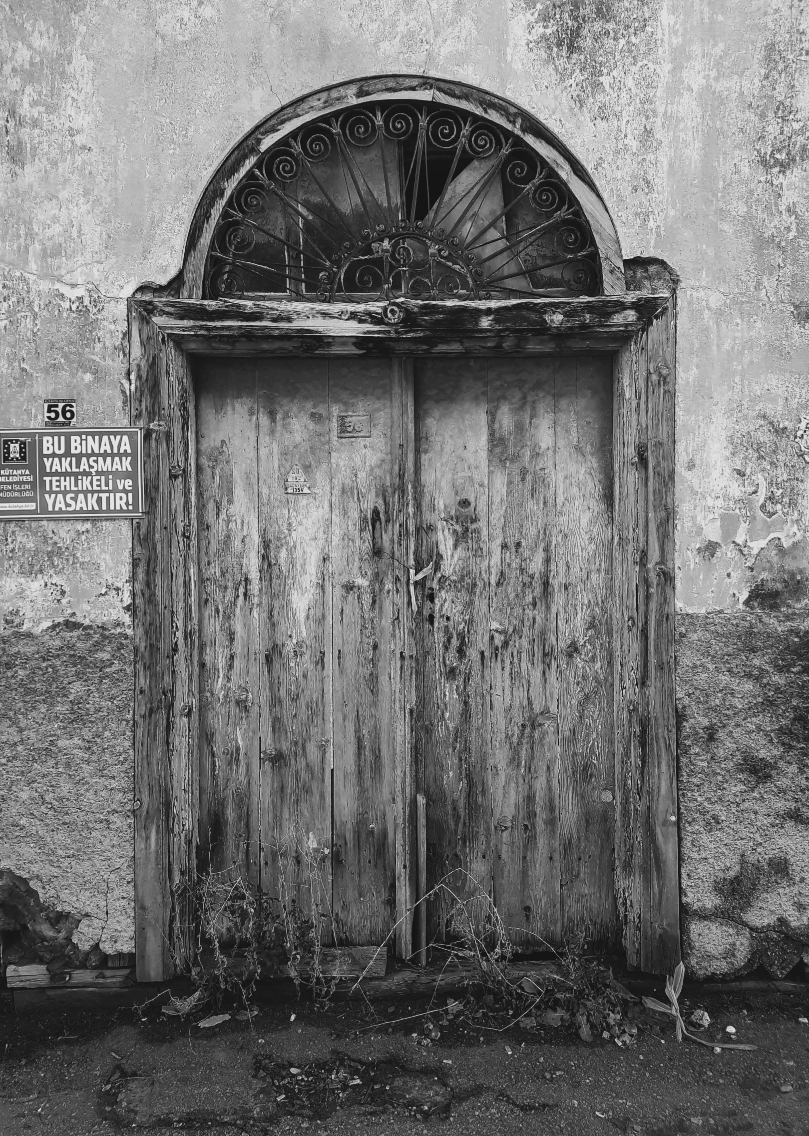 a black and white photo of an old door, by Giuseppe Camuncoli, old signs, - photorealistic, ruin, rounded