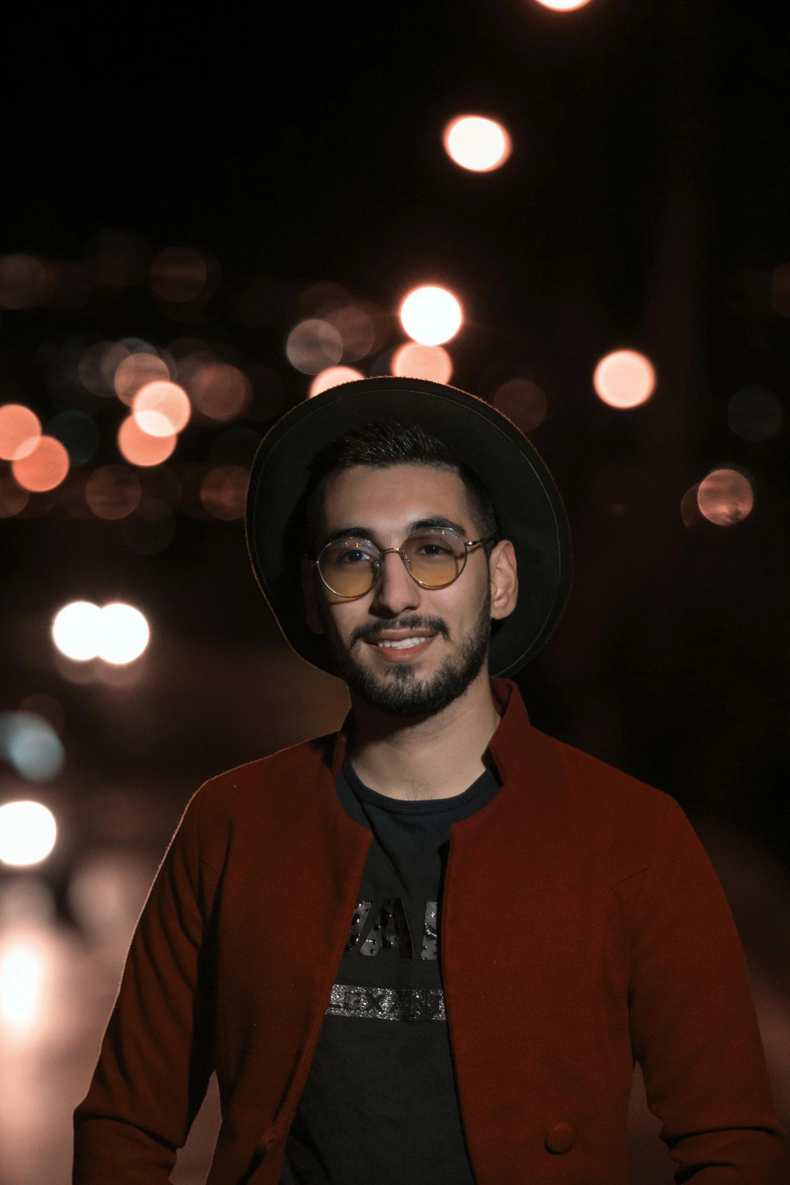 a man standing in the middle of a street at night, a picture, inspired by Ahmed Yacoubi, pexels contest winner, photorealism, jewish young man with glasses, caracter with brown hat, headshot profile picture, lgbtq