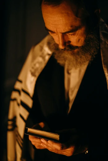 a man with a long beard using a cell phone, by Micha Klein, pexels, symbolism, biblical art lighting, holy ceremony, benjamin netanyahu, wearing robes and neckties