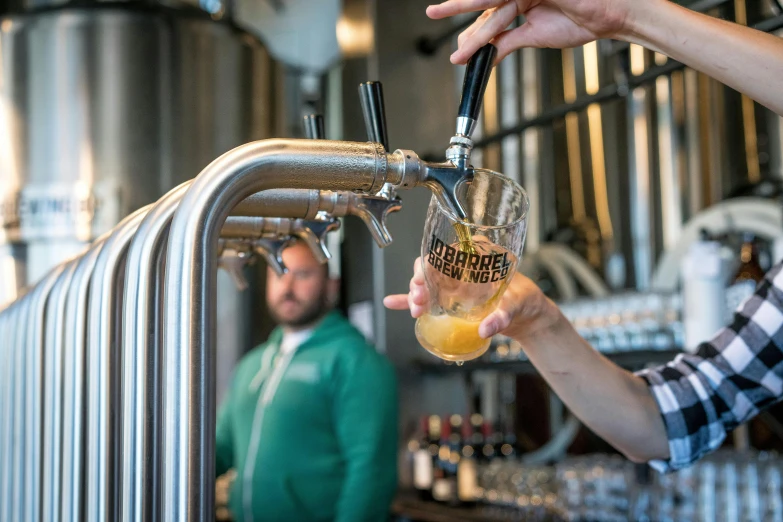 a person pouring a beer into a glass, by Bertram Brooker, unsplash, private press, “ iron bark, pulling the move'derp banshee ', where a large, special