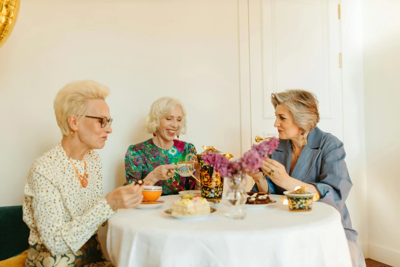 a group of older women sitting around a table, by Emma Andijewska, pexels, floral clothes, avatar image, 3 - piece, hot food