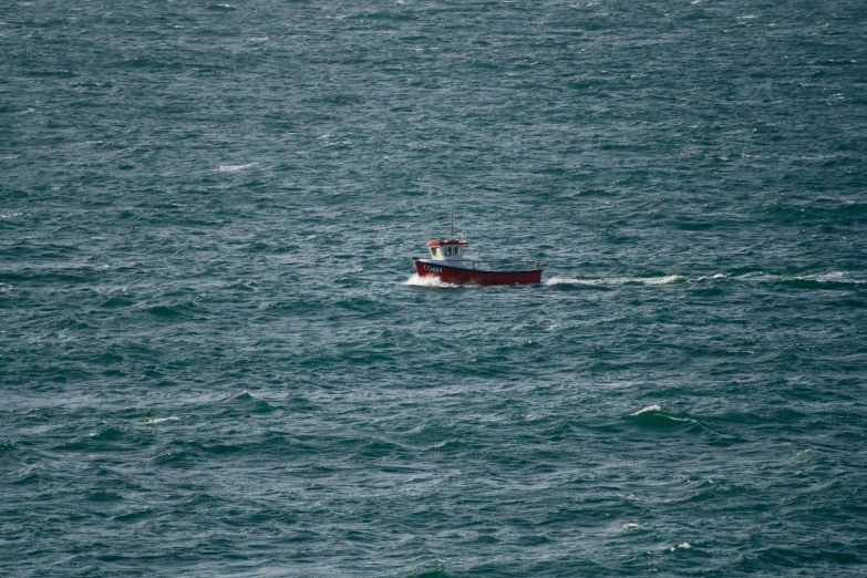 a red and white boat in the middle of the ocean, a picture, unsplash, hurufiyya, cornwall, 2 0 0 mm telephoto, fisherman, very tiny
