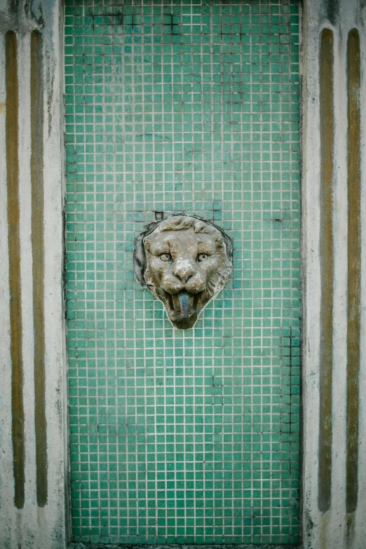 a green door with a lion head on it, a mosaic, by Elsa Bleda, unsplash, made of liquid metal and marble, 1950, fountains, award winning photo