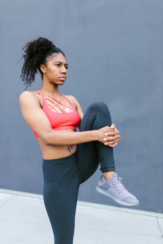 a woman in a pink top and black leggings, by Jessie Algie, pexels contest winner, aida muluneh, muscular thighs, various posed, square