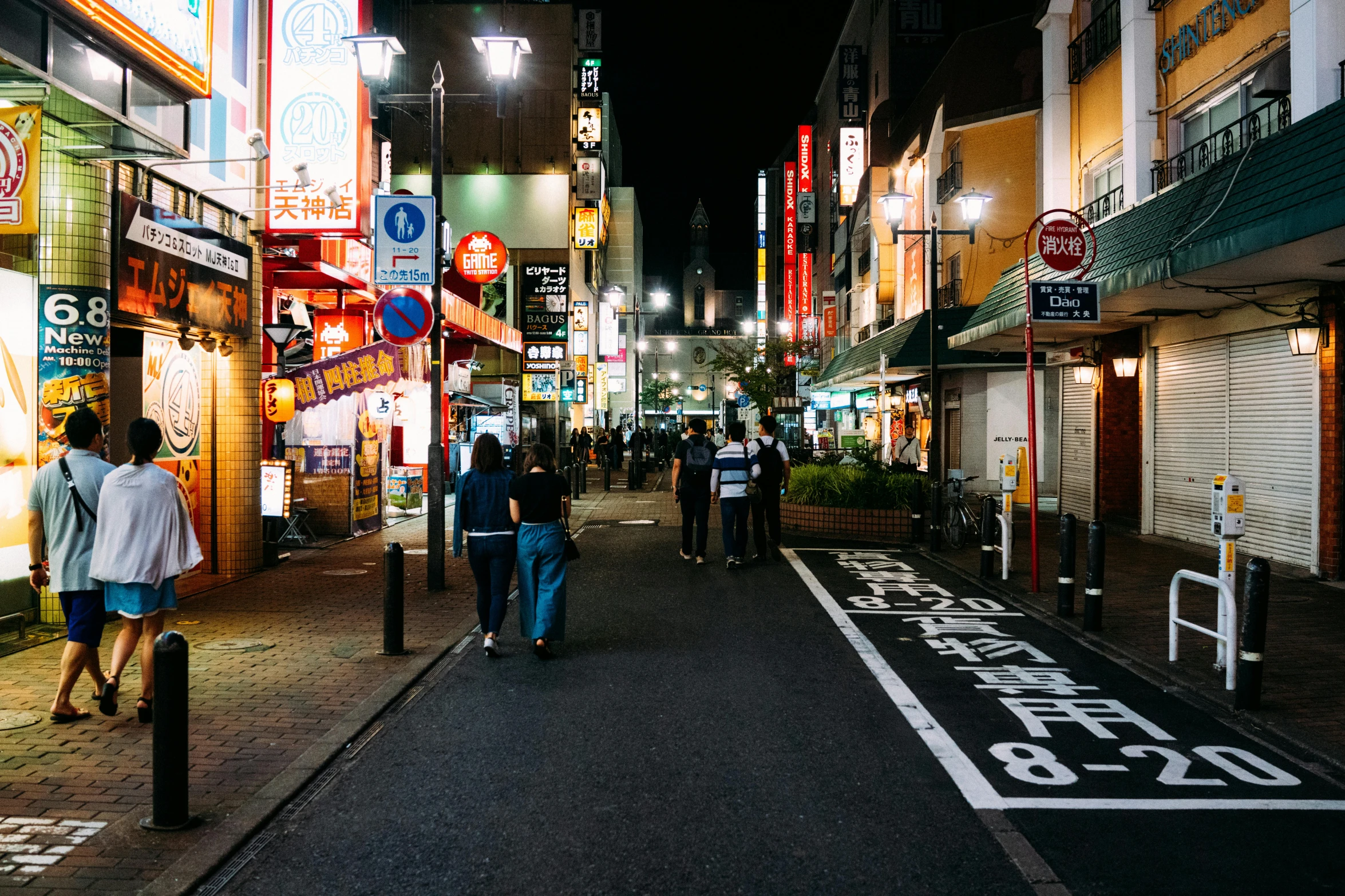 a group of people walking down a street at night, by Carey Morris, pexels contest winner, ukiyo-e, street signs, the place is just really small, clean streets, in the middle of the city