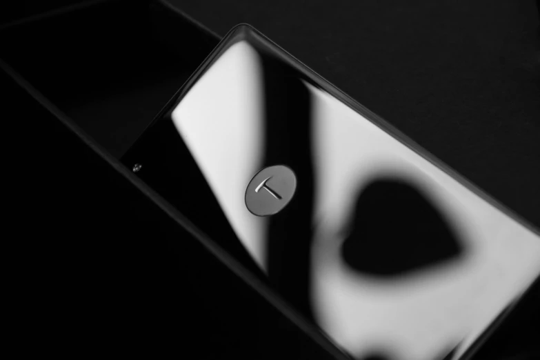 a close up of a cell phone on a table, a black and white photo, by Patrick Pietropoli, unsplash, conceptual art, lacquered glass, square black pupil centered, keyshot product render, vantablack gi