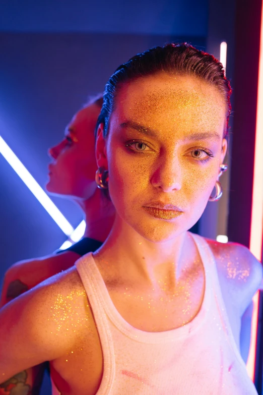 a woman standing in front of a neon light, inspired by David LaChapelle, trending on pexels, hyperrealism, dewy skin, two models in the frame, stippled light, sydney sweeney