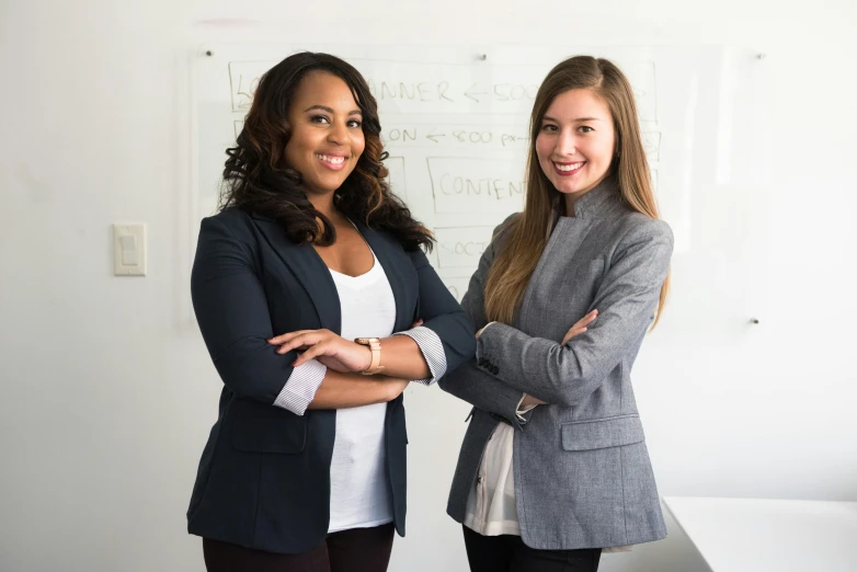 two women standing next to each other in an office, a photo, 15081959 21121991 01012000 4k, promotional image, a group of people, confident action pose