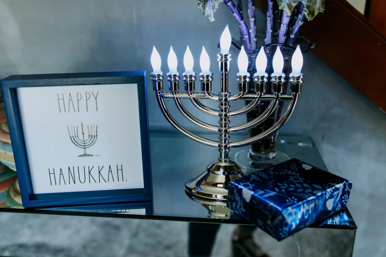 a silver menorah sitting on top of a glass table, by Julia Pishtar, blue neon accents, navy, 1 6 x 1 6, happy lighting