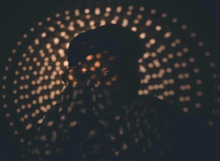 a person that is standing in the dark, visual art, faces covered in shadows, light circles, portrait featured on unsplash, brown atmospheric lighting