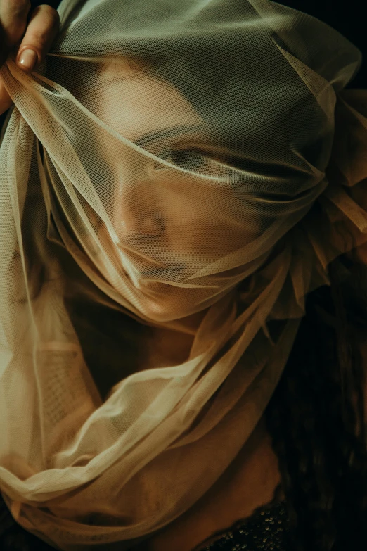 a woman with a veil covering her head, an oil painting, unsplash contest winner, tonalism, draped in flowing fabric, golden filter, close-up portrait film still, photography portrait 4 k