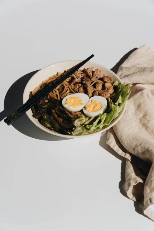 a bowl of noodles with an egg and chopsticks, unsplash, salad, set against a white background, cloth wraps, pork